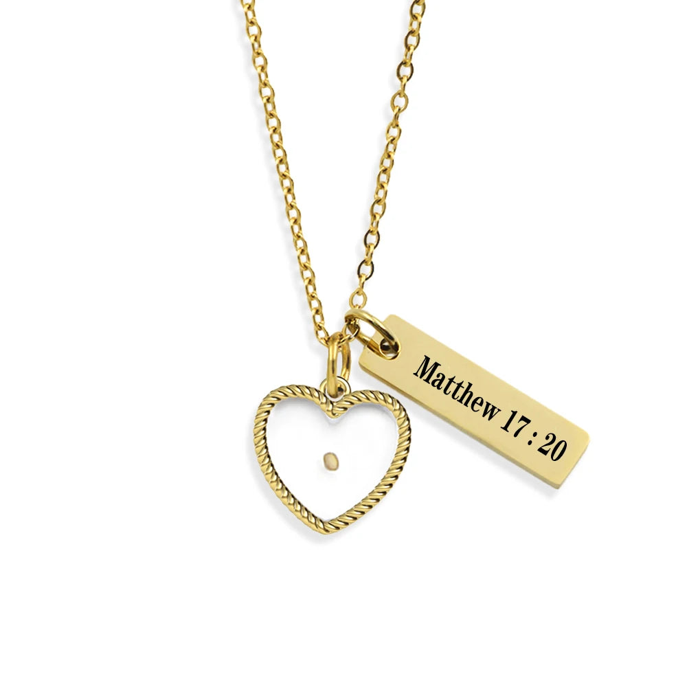 Gold necklace with heart pendant and engraved bar on a white background