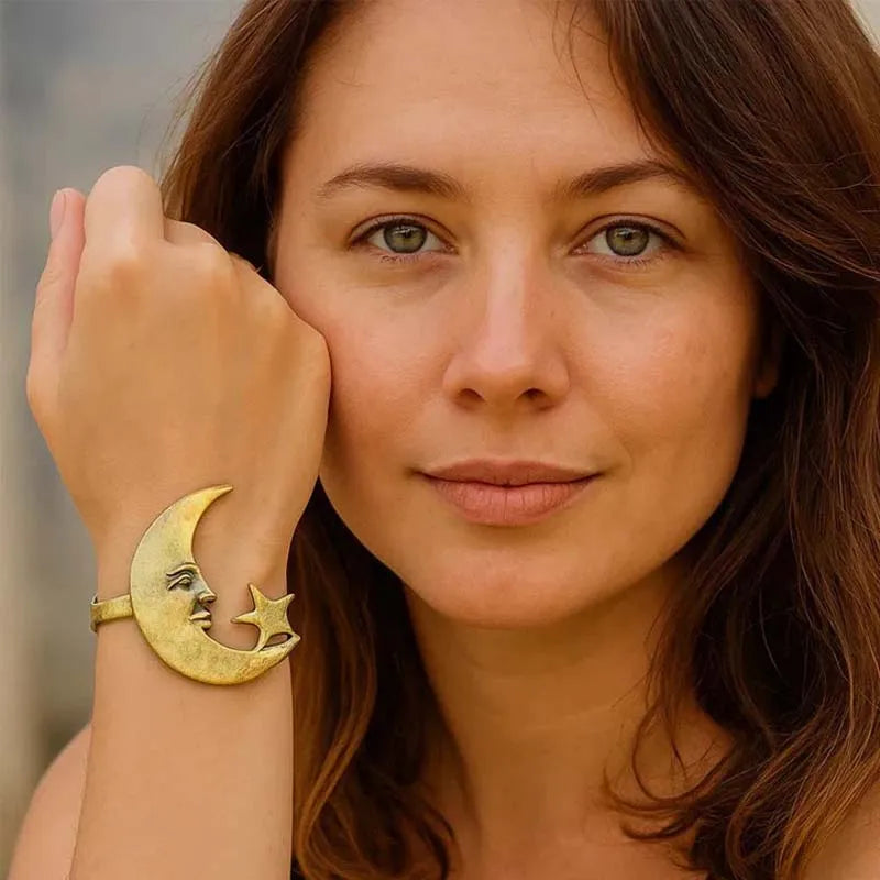 Woman wearing a gold bracelet with a moon and star design.