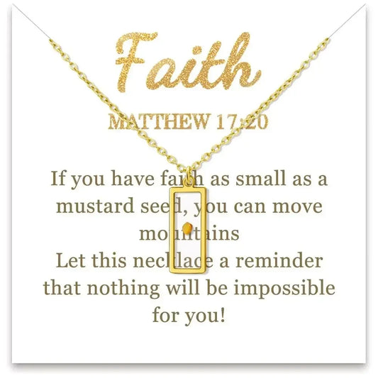 A gold necklace with a small rectangular pendant displayed on a white card. The card features the word 'Faith' in glittery gold, the Bible verse Matthew 17:20, and inspirational text in brown lettering.