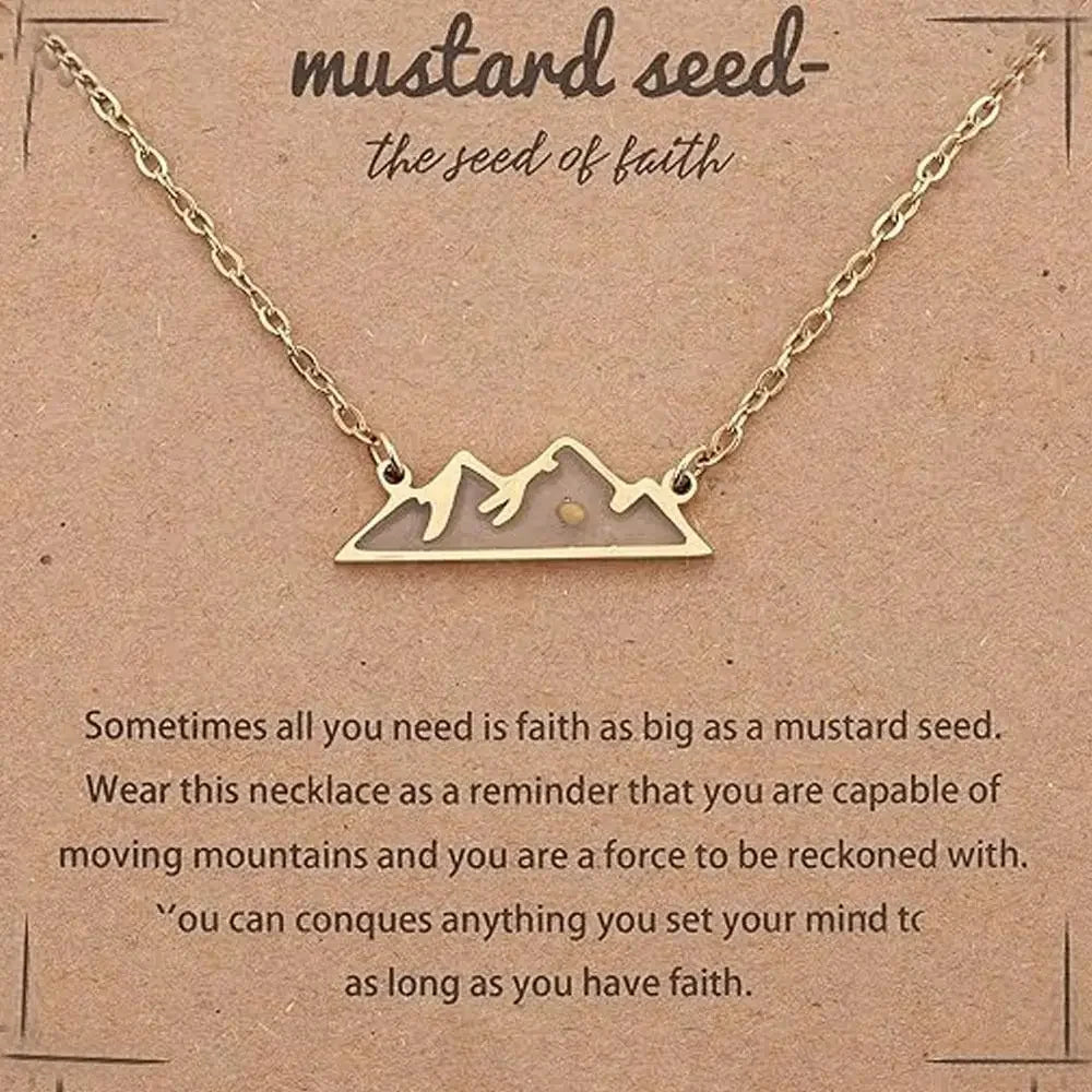 Gold necklace with a mountain silhouette pendant on a brown kraft card that reads 'mustard seed- the seed of faith' with inspirational text below.