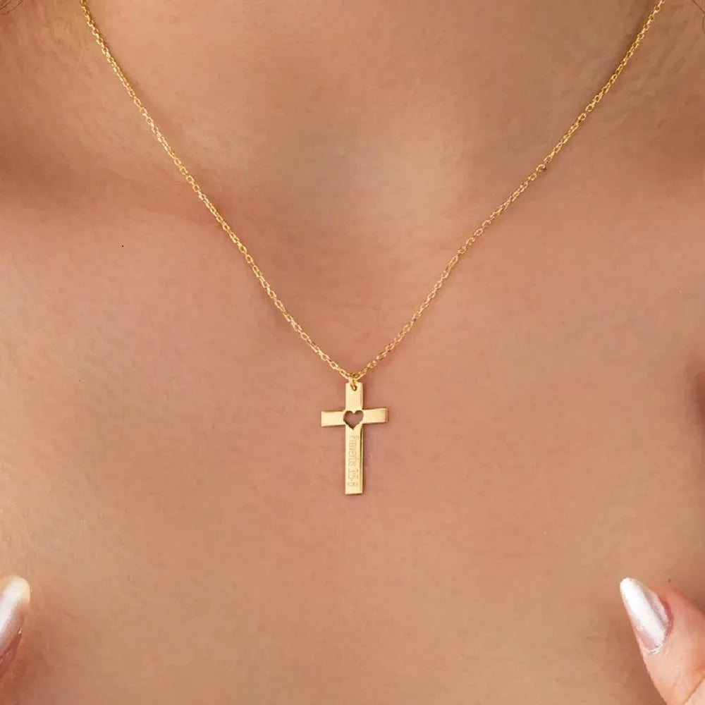 Gold cross necklace on a person's neck against a neutral background