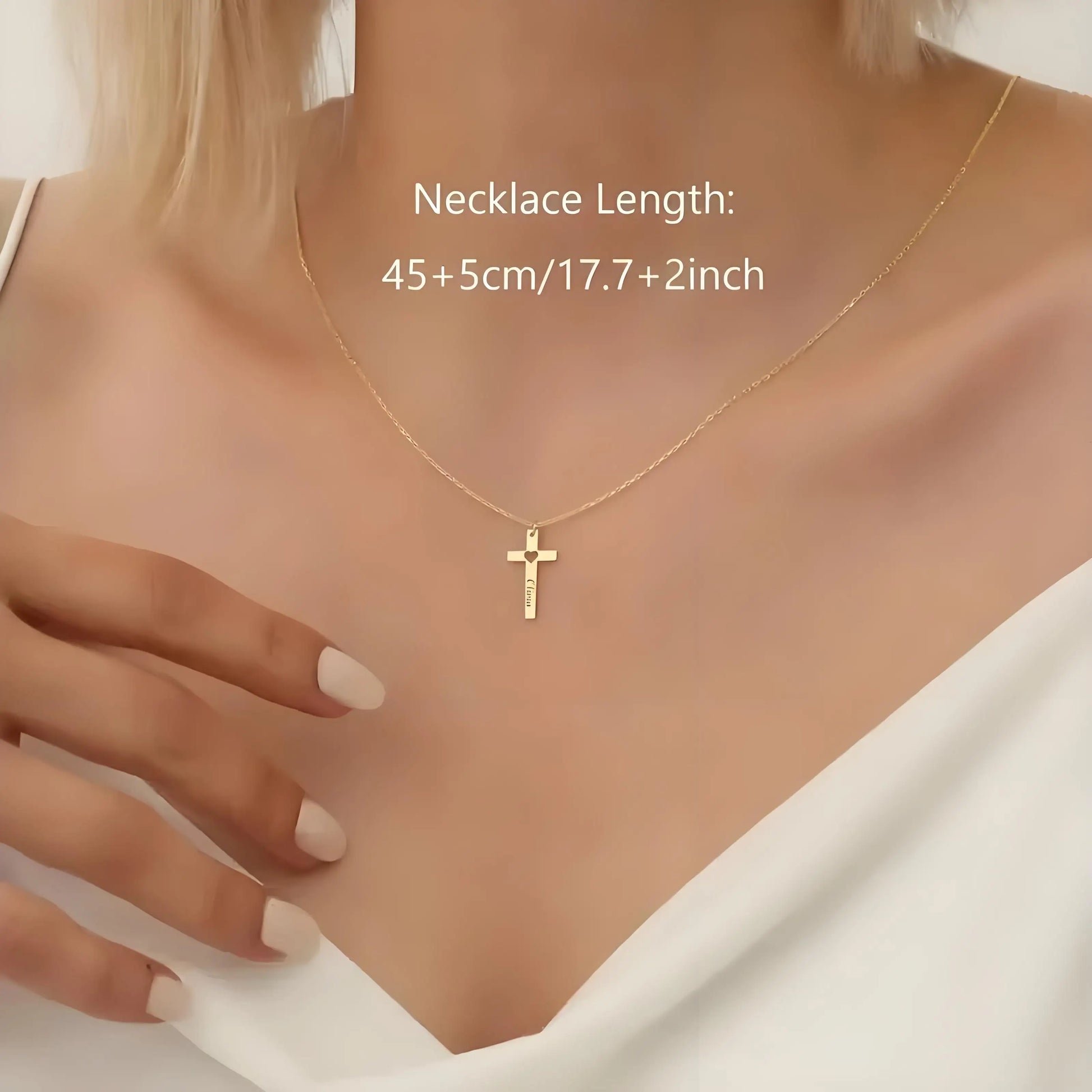 Gold necklace with a cross pendant on a model, showing necklace length.