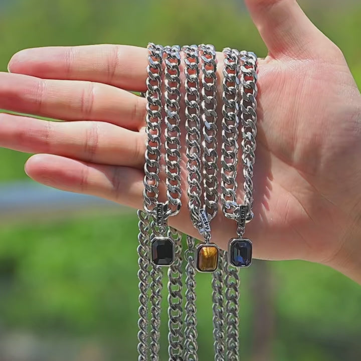 Close-up video of stainless steel zircon pendant necklace with blue, black, and brown stones