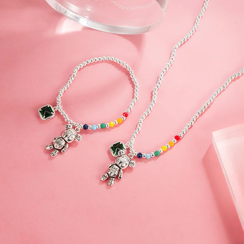 Necklace with teddy bear pendants and colorful beads on a pink background