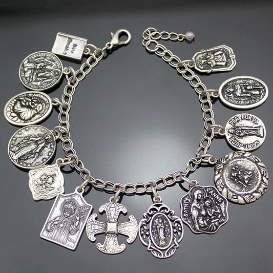 Silver charm bracelet with various charms on a dark background