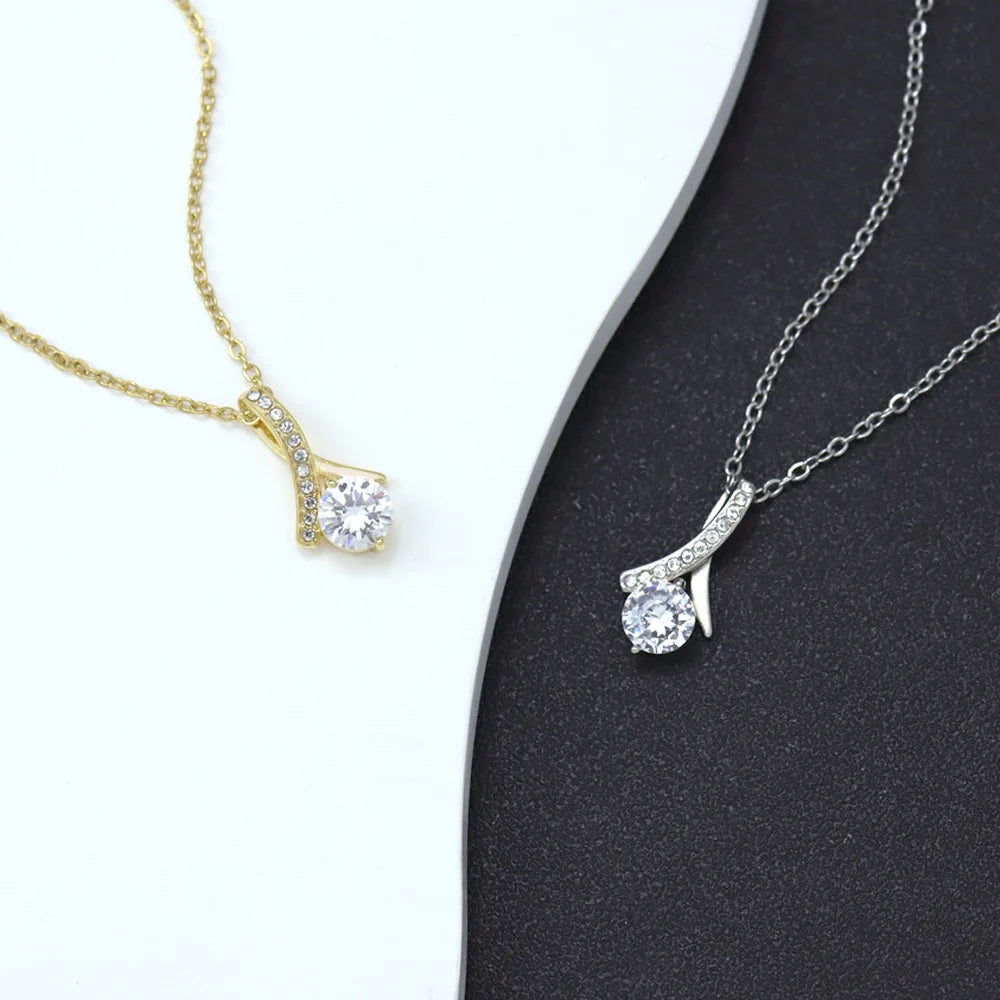 Two diamond pendants, one gold and one silver, on a black and white background.
