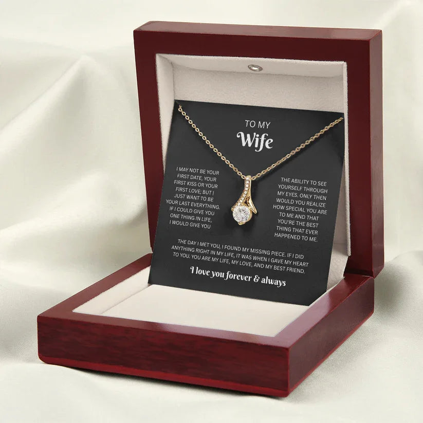 Necklace with a sentimental card in a wooden box on a white fabric background