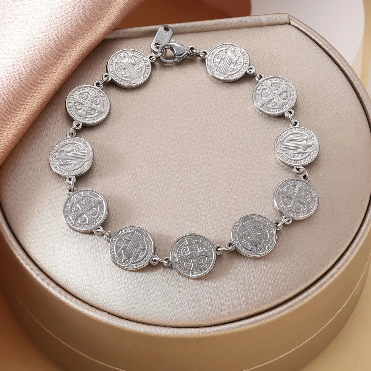 Silver coin bracelet on a beige circular box