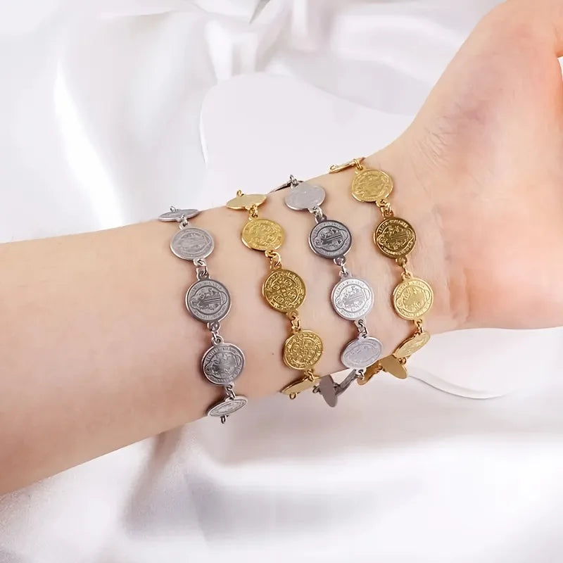 Bracelet with coin-shaped charms on a wrist against a white background