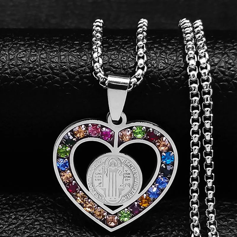 Heart-shaped pendant with colorful stones and a coin inside, on a black textured background