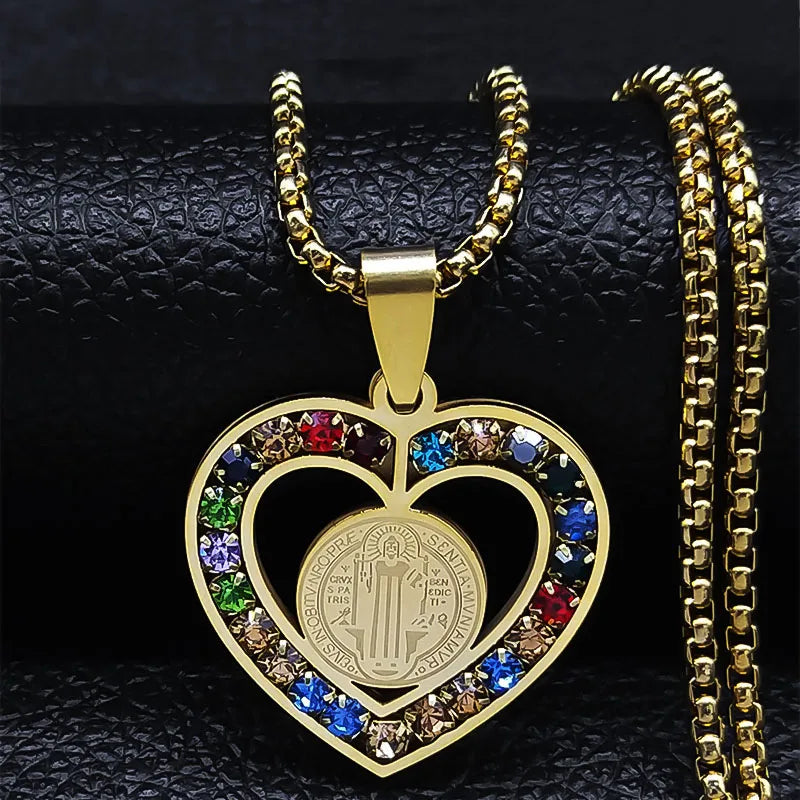 Gold heart-shaped pendant with colorful stones on a black textured background