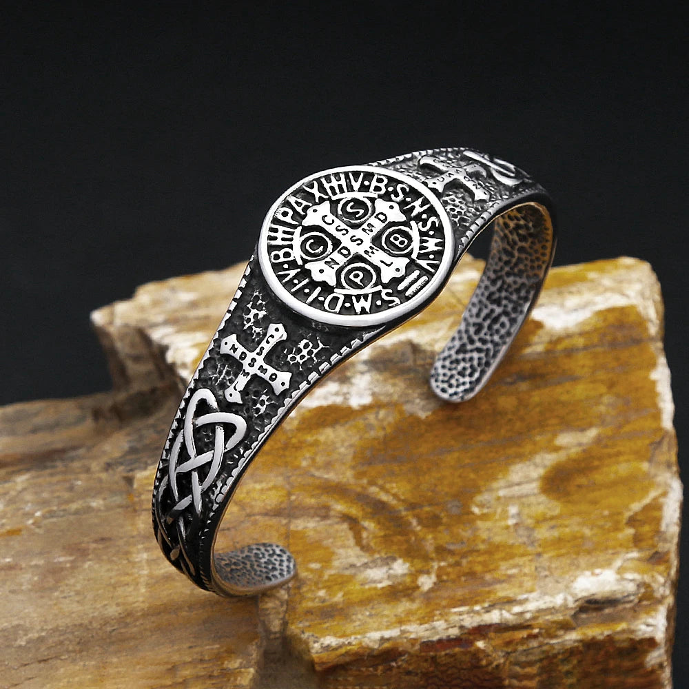 Silver bracelet with intricate designs on a stone surface
