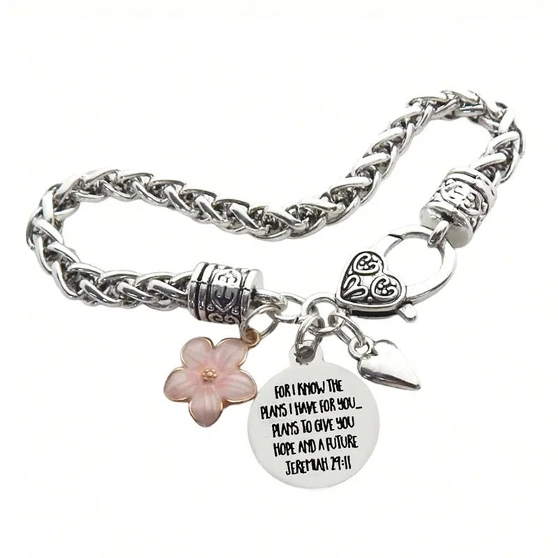 Silver bracelet with floral and heart charm on a white background