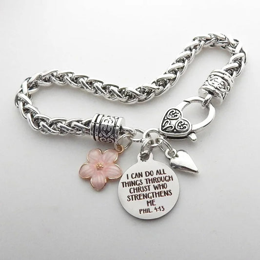 Silver bracelet with bible verse charm on a light gray background
