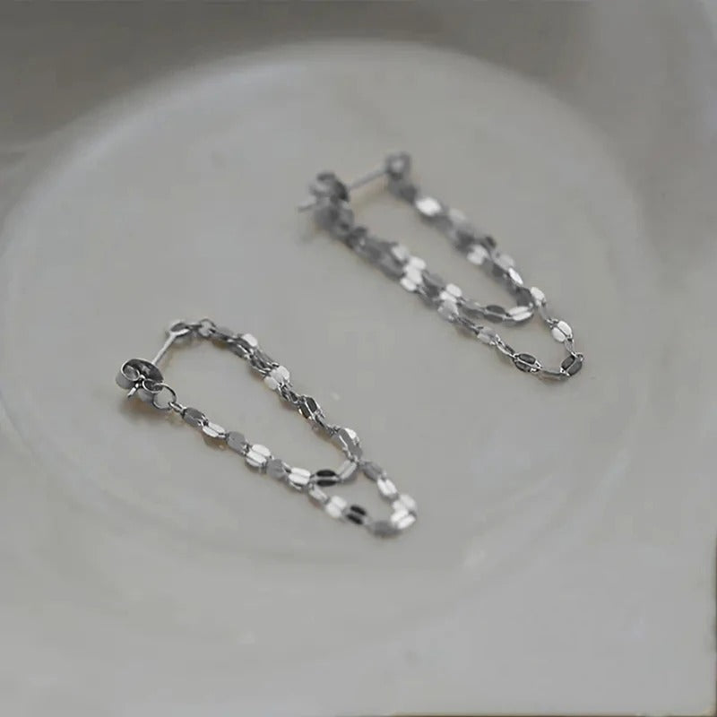 Silver chain earrings on a light gray background