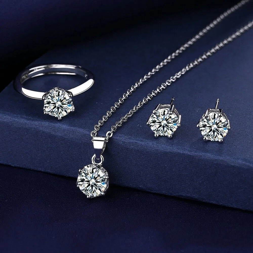 Silver jewelry set with ring, necklace, and earrings on a dark blue background