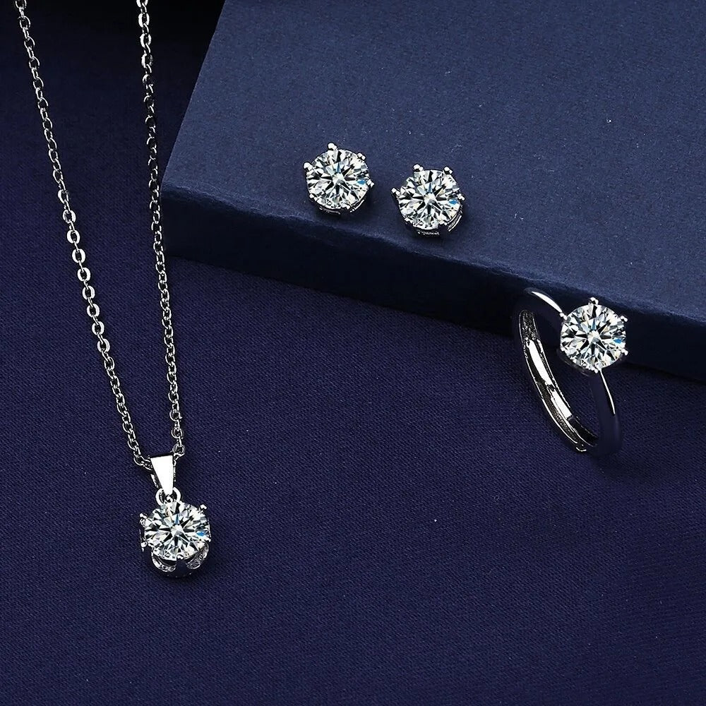 Silver jewelry set with necklace, earrings, and ring on a dark blue background