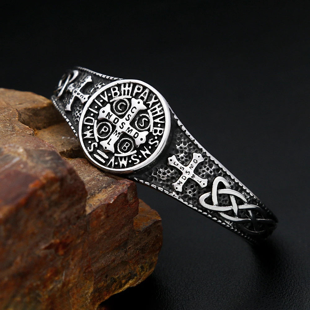 Silver bracelet with intricate designs on a dark background
