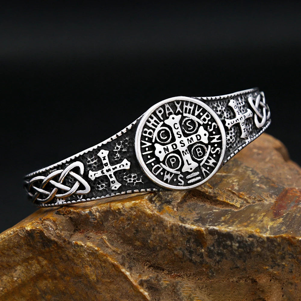Silver bracelet with intricate designs on a stone surface