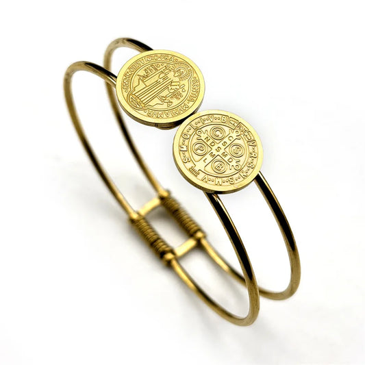 Gold bangle with circular medallions on a white background