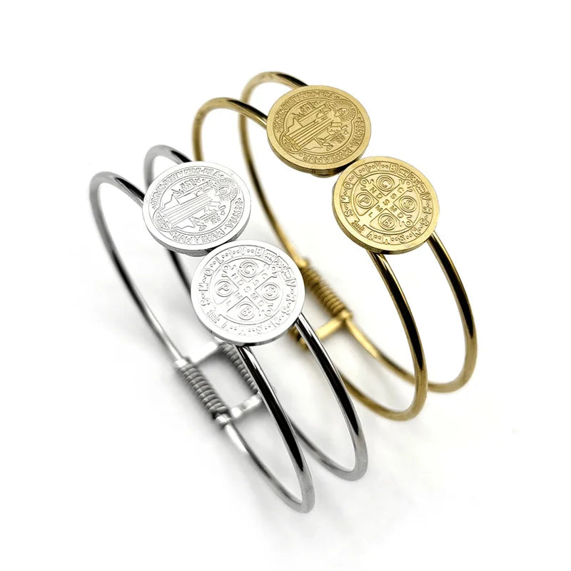 Two bangles in gold and silver with engraved designs on a white background