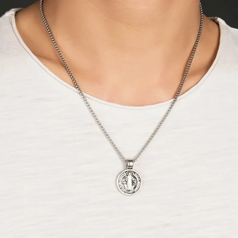 Silver necklace with a pendant on a person wearing a white shirt
