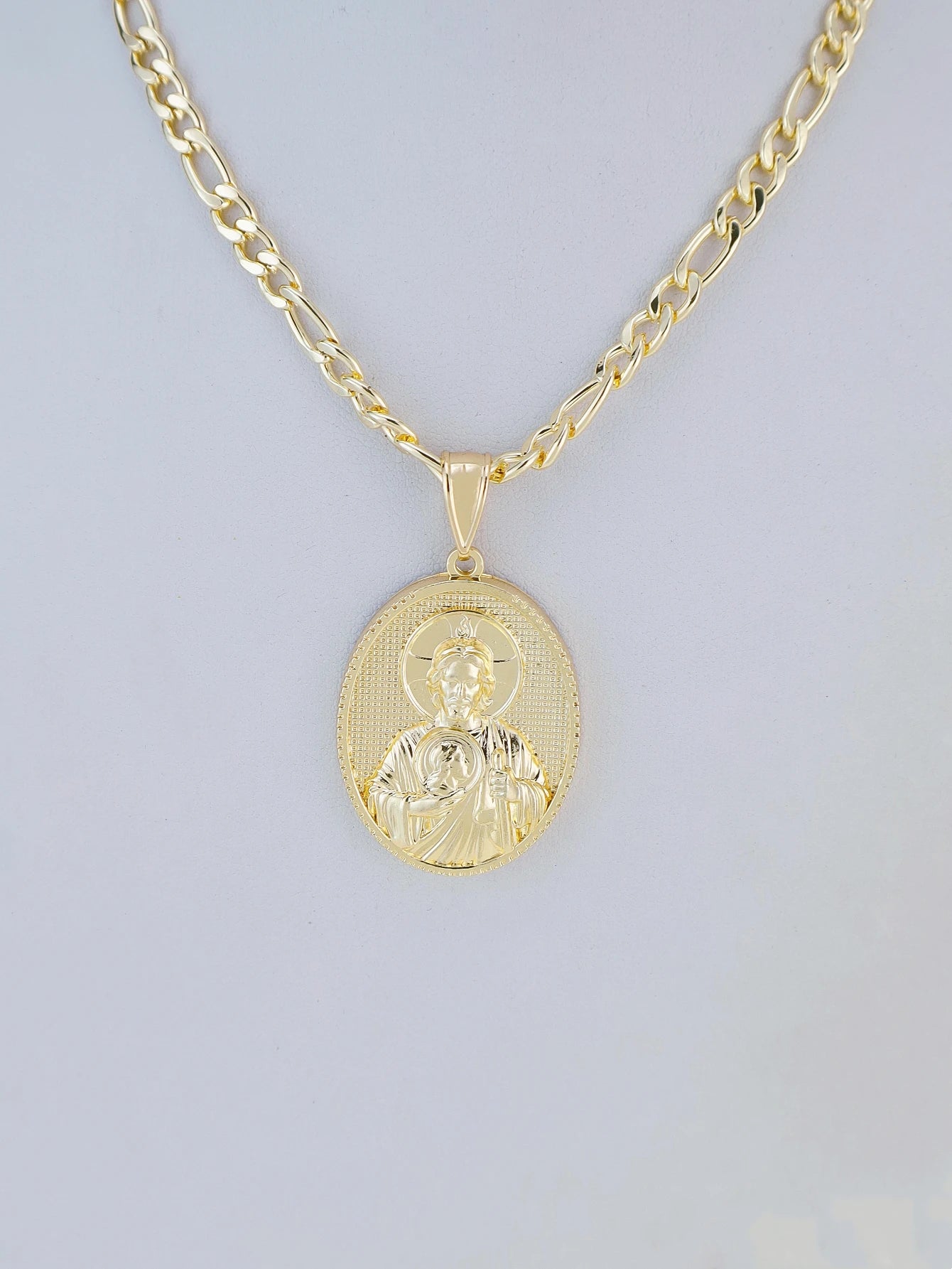 Gold necklace with a pendant on a light gray background