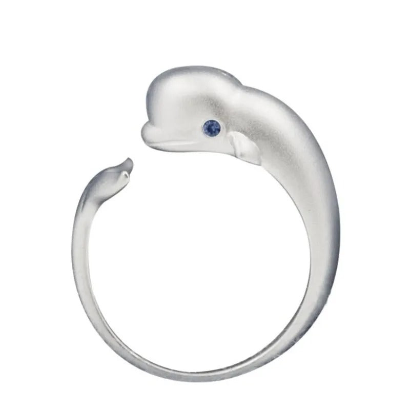 Silver dolphin-shaped ring with a blue gemstone on a white background