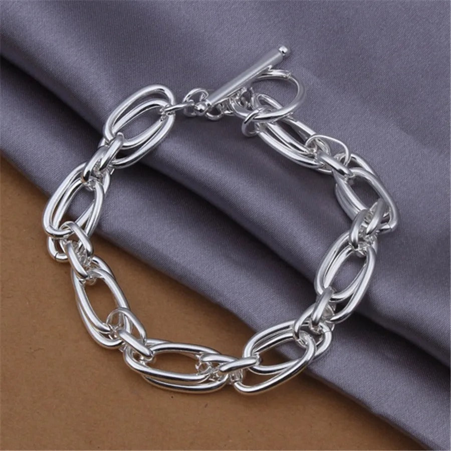 Silver chain bracelet on a textured fabric background
