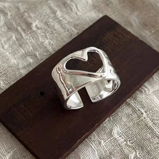 Silver ring on a wooden block with a textured background