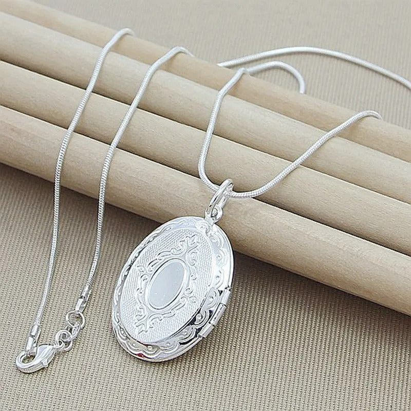 Silver necklace with an oval pendant on a beige background