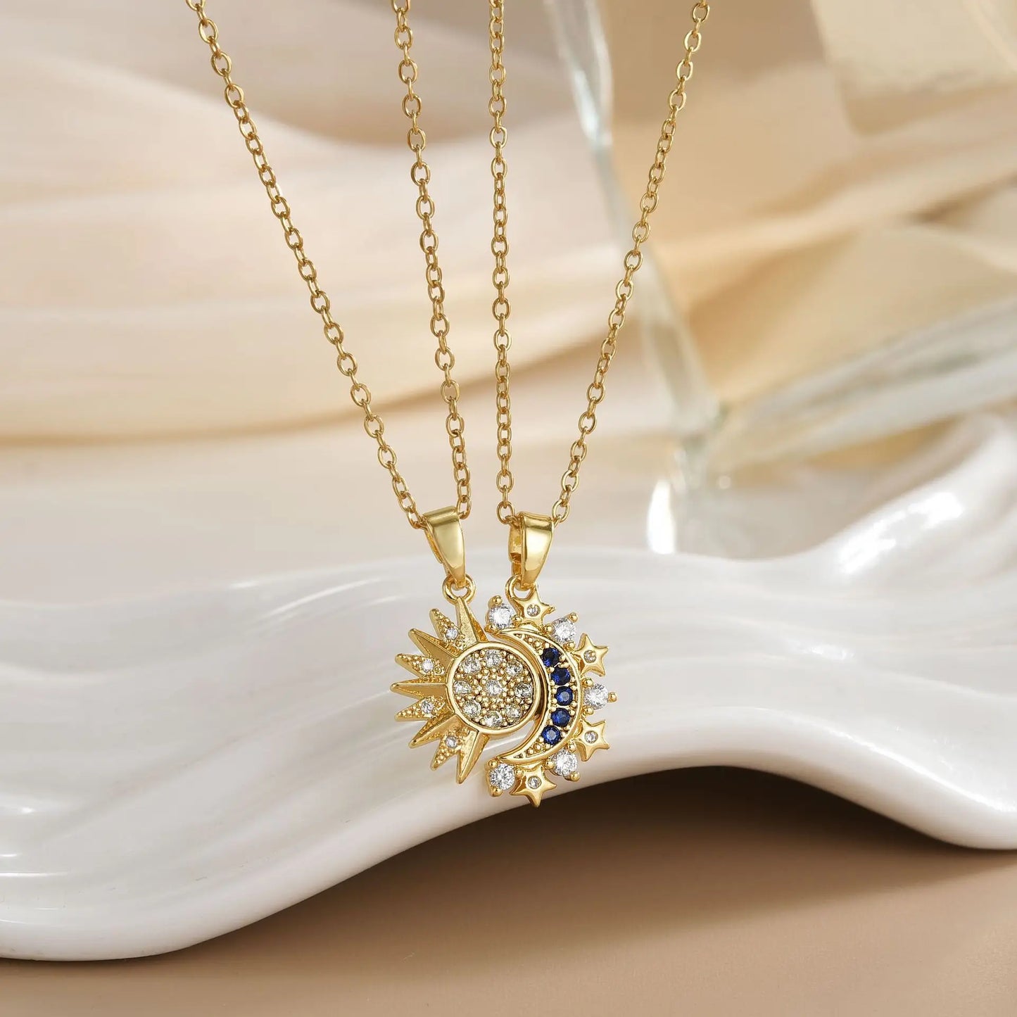 Gold necklace with a decorative pendant on a white ceramic dish