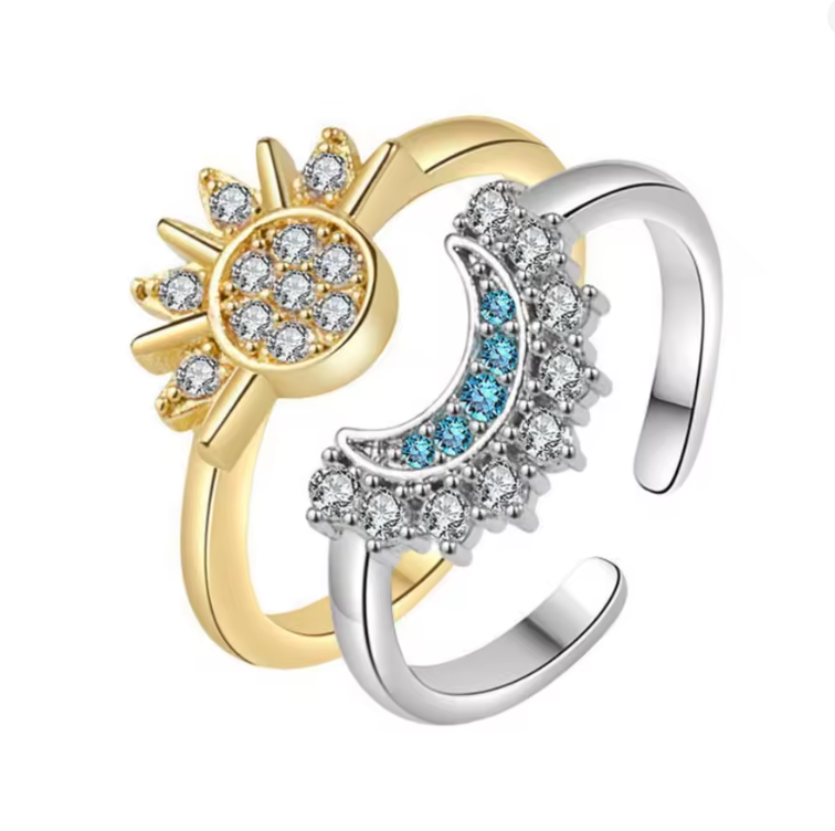Two rings, one gold and one silver, each with decorative elements on a white background.