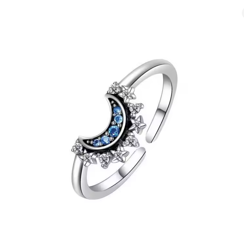 Silver ring with moon and star design on a white background