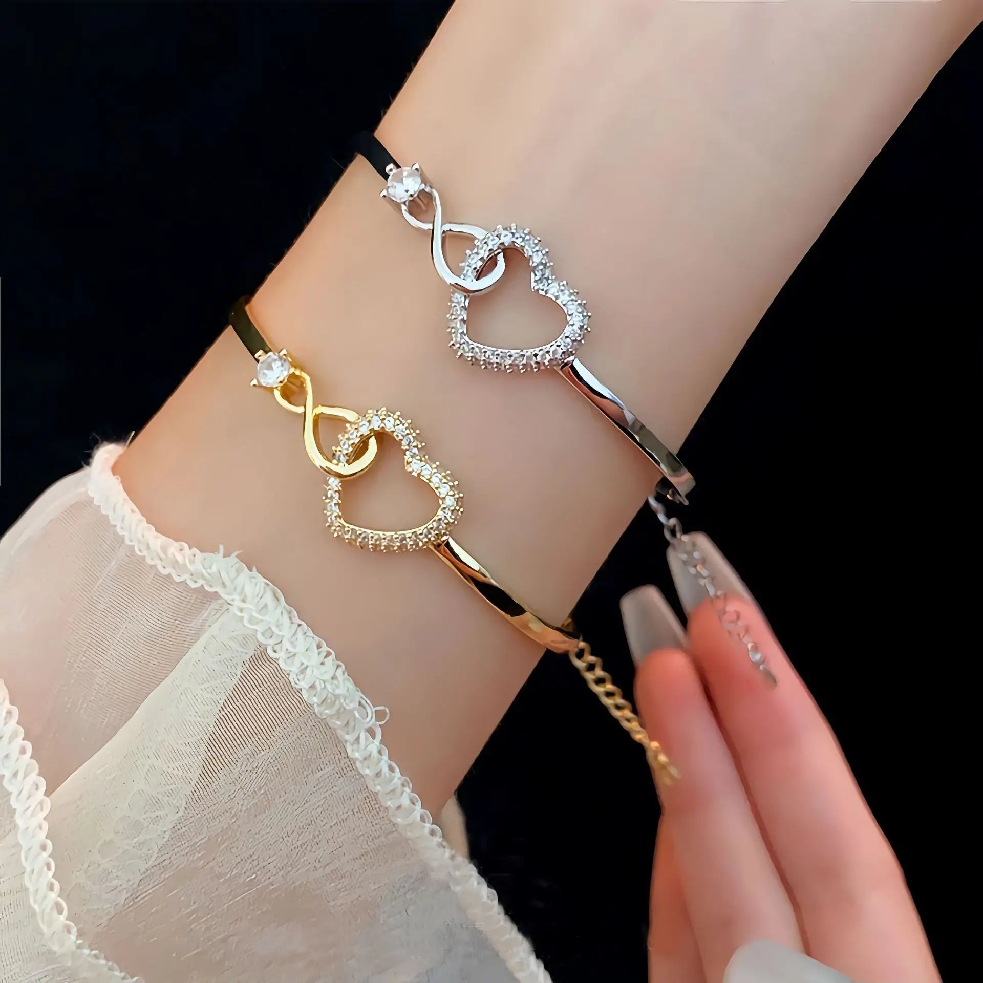 Three heart-shaped bracelets on a wrist against a black background