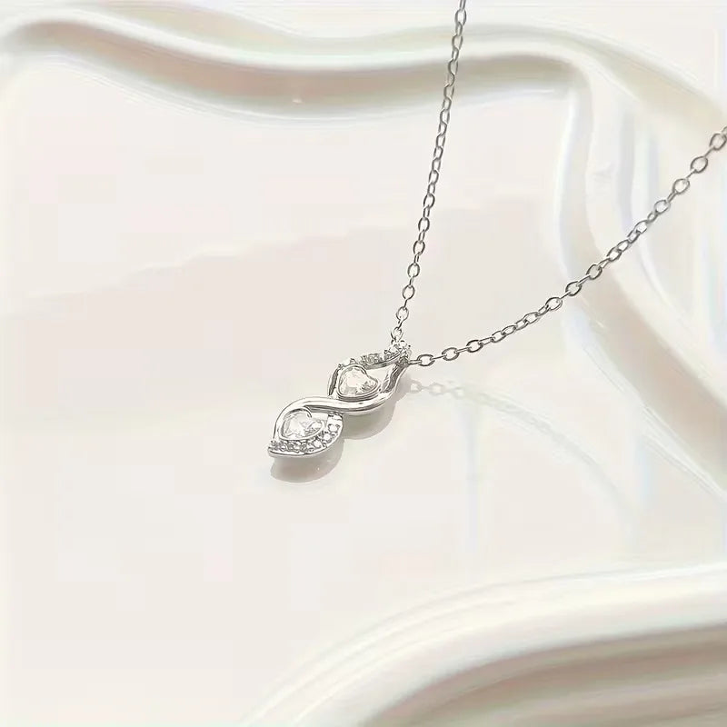 Silver necklace with a heart-shaped pendant on a white background