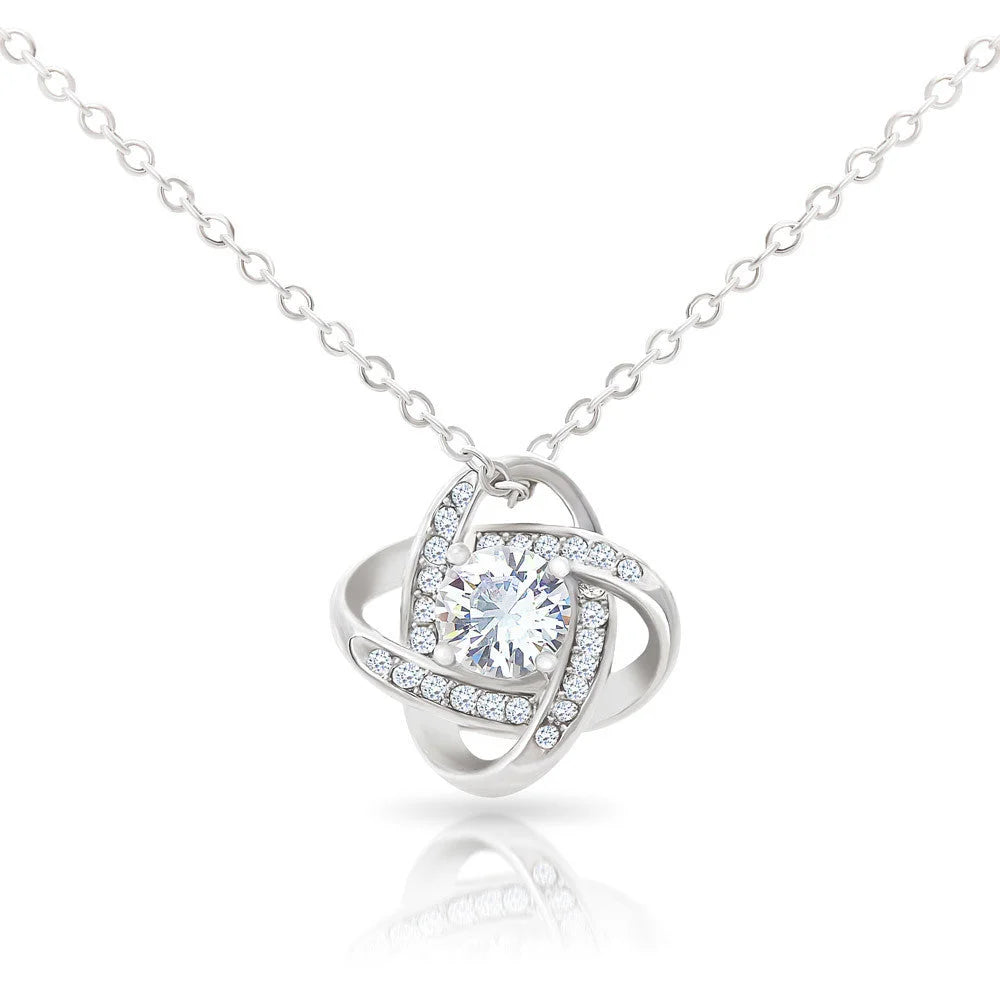 Silver necklace with a round pendant on a white background