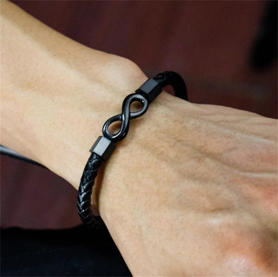 Black braided bracelet on a wrist with a blurred background