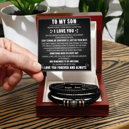 Hand holding a box with leather bracelets and a card inside, set against a blurred indoor background.