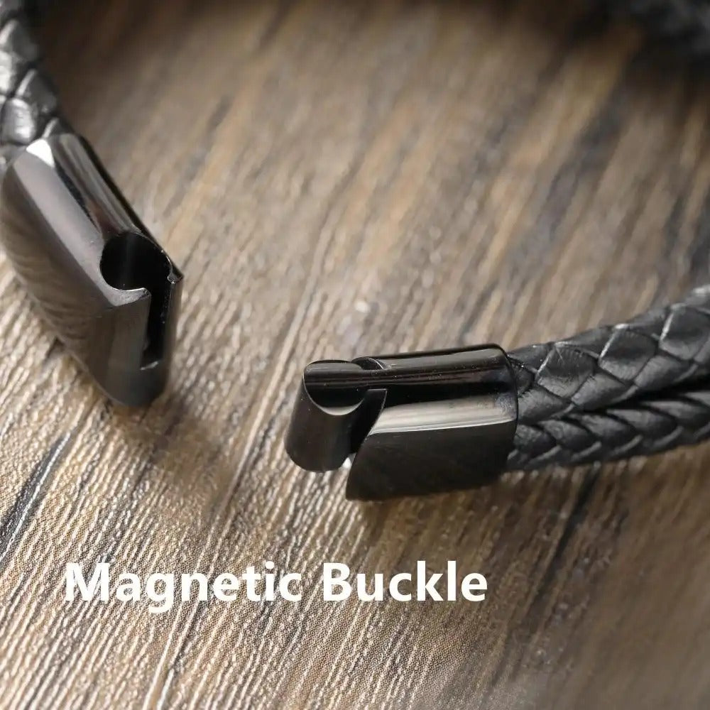 Close-up of a magnetic buckle on a braided leather strap with text overlay on a wooden surface.