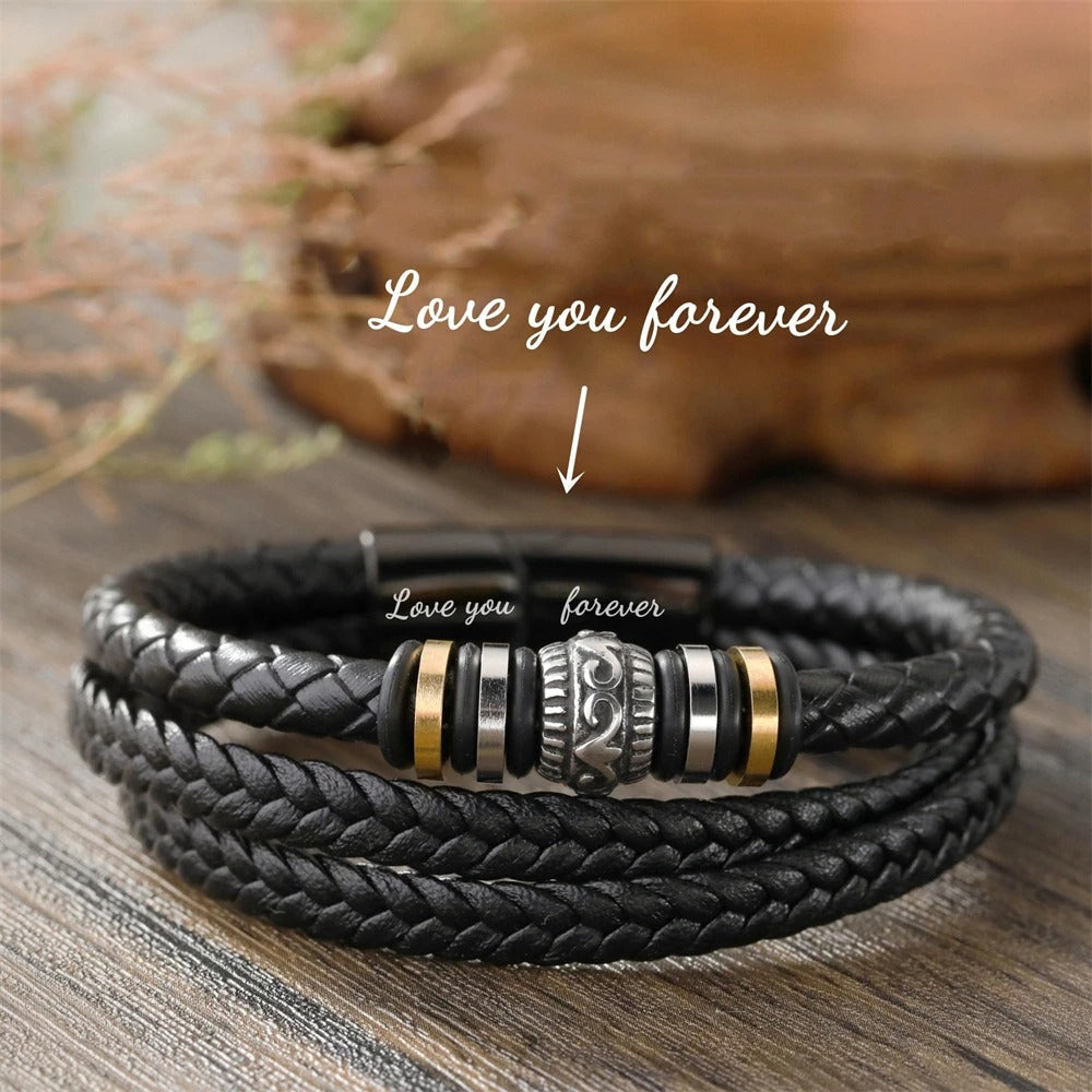 Black braided leather bracelet with metal beads on a wooden surface, featuring the text 'Love you forever'.
