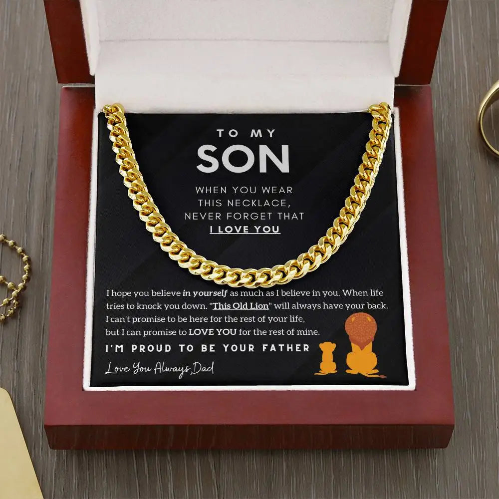 Gold chain necklace in a box with a message to a son from his father, on a wooden surface.