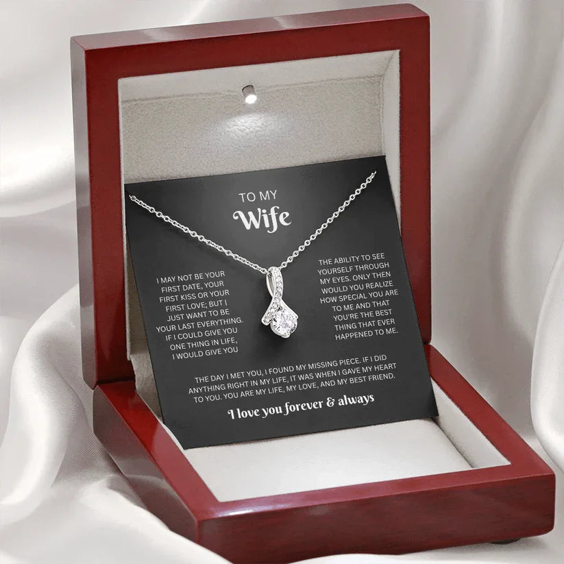 Necklace in a red box with a sentimental message card on a white fabric background