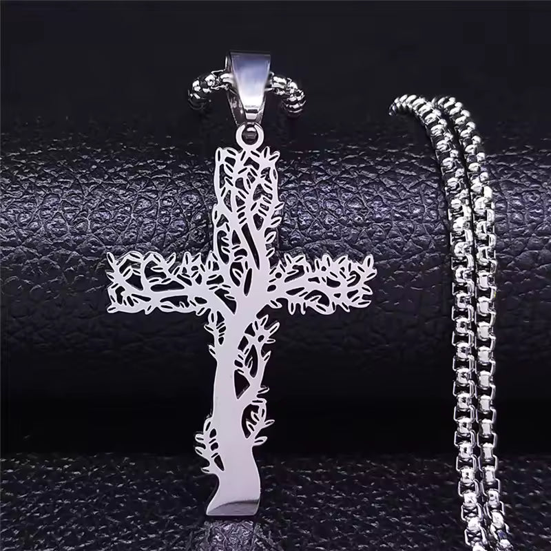Silver cross pendant with chain on a textured black surface