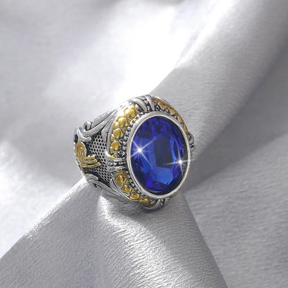Ring with blue gemstone and gold accents on a white fabric background