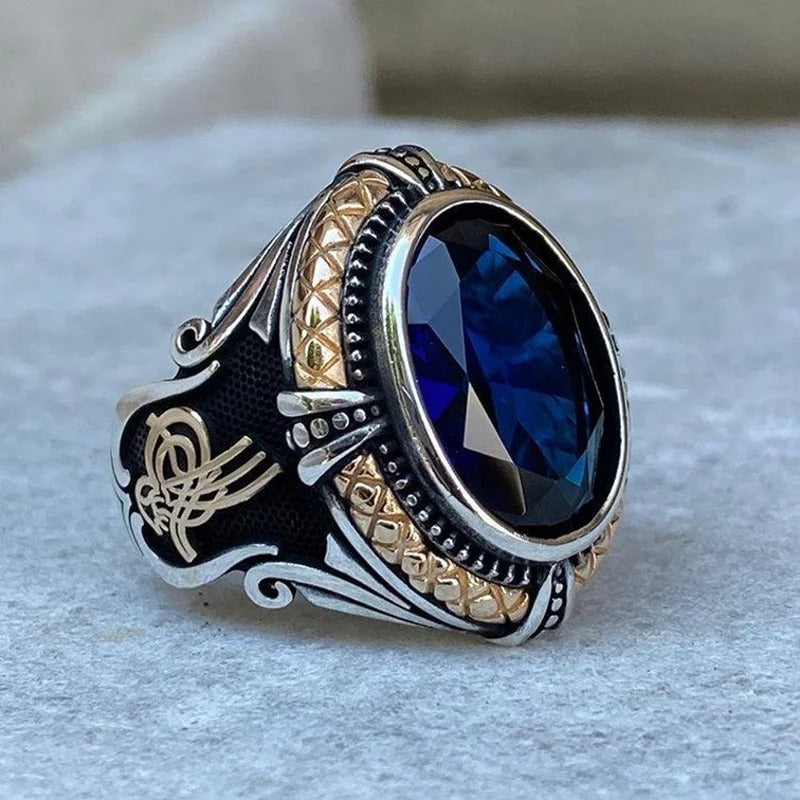 Decorative ring with blue gemstone on a light gray background
