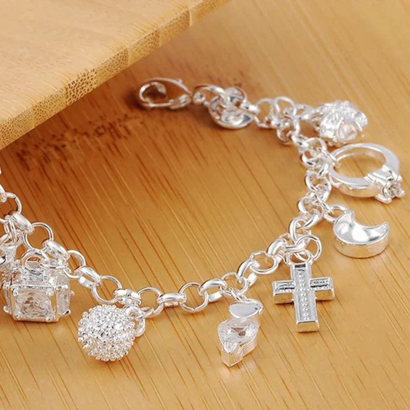Silver charm bracelet on a wooden surface