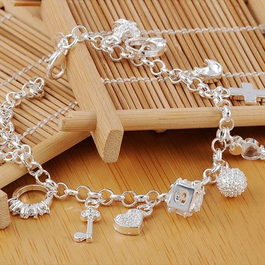 Silver charm bracelet on a wooden surface