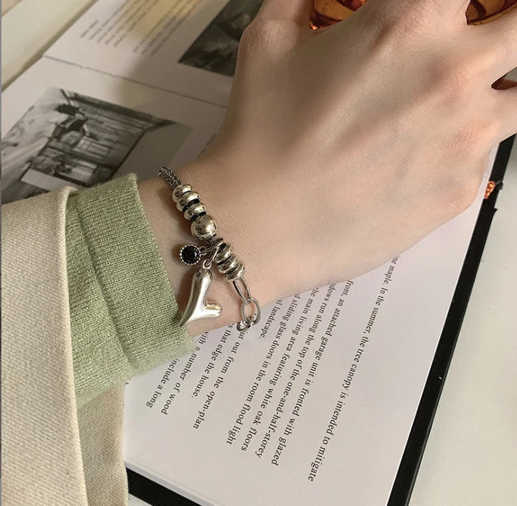 Hand wearing a bracelet with a shoe charm on an open book