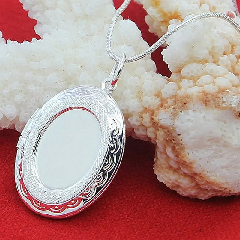 Silver locket on a red background with coral
